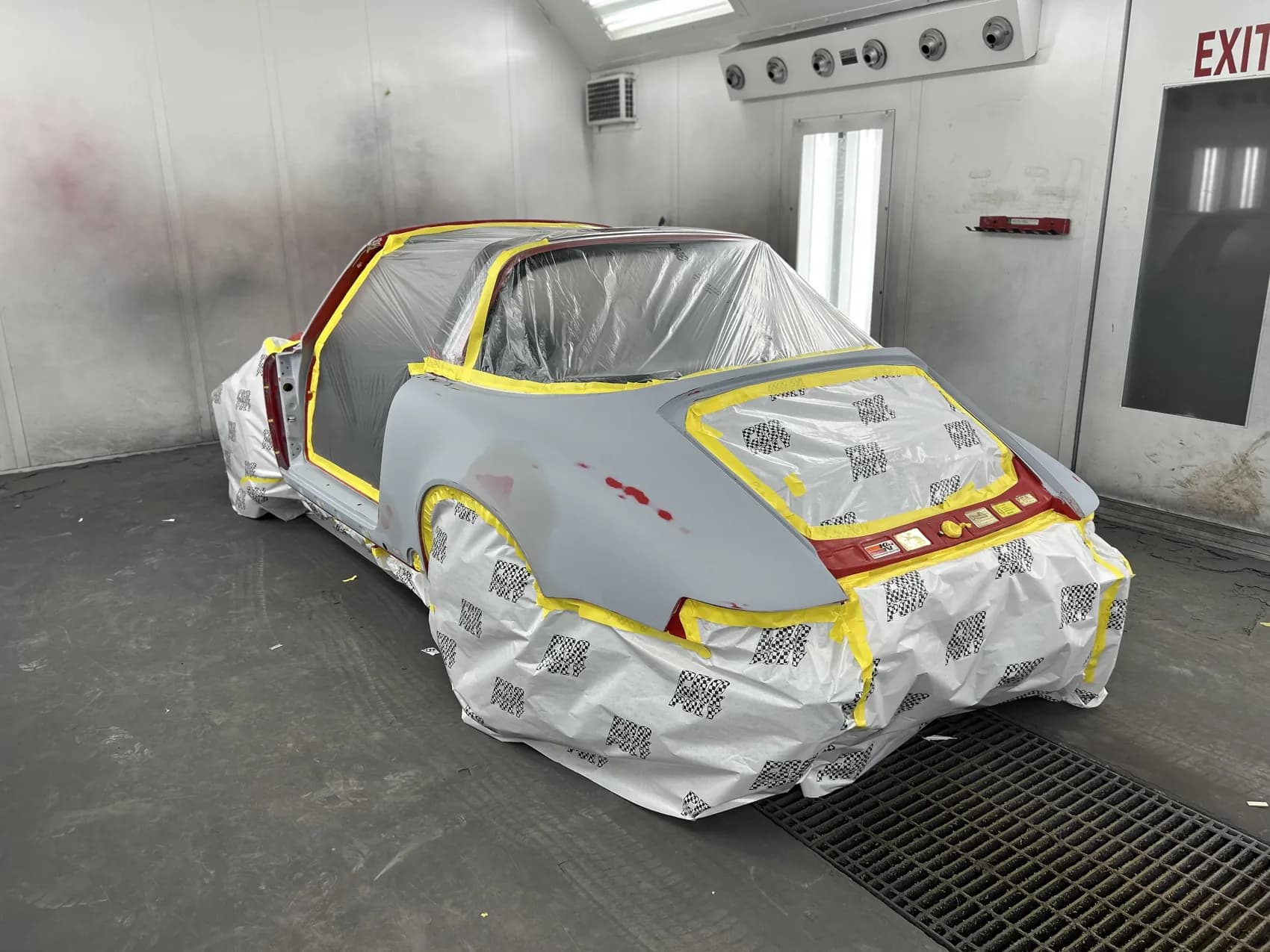 Classic Porsche 911 masked and prepared for refinishing in the spray booth.