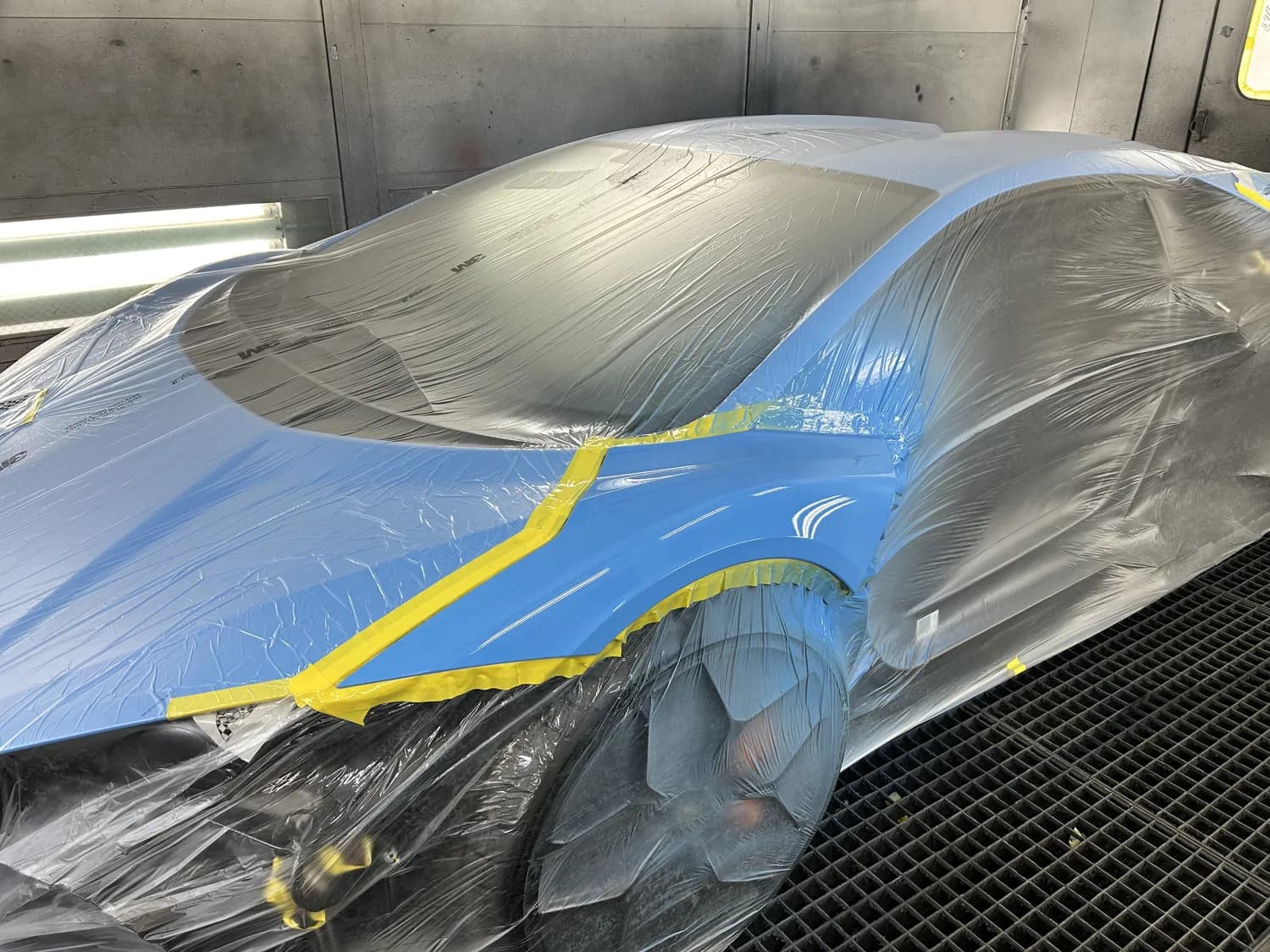 Car masked with tape, prepared for refinishing.
